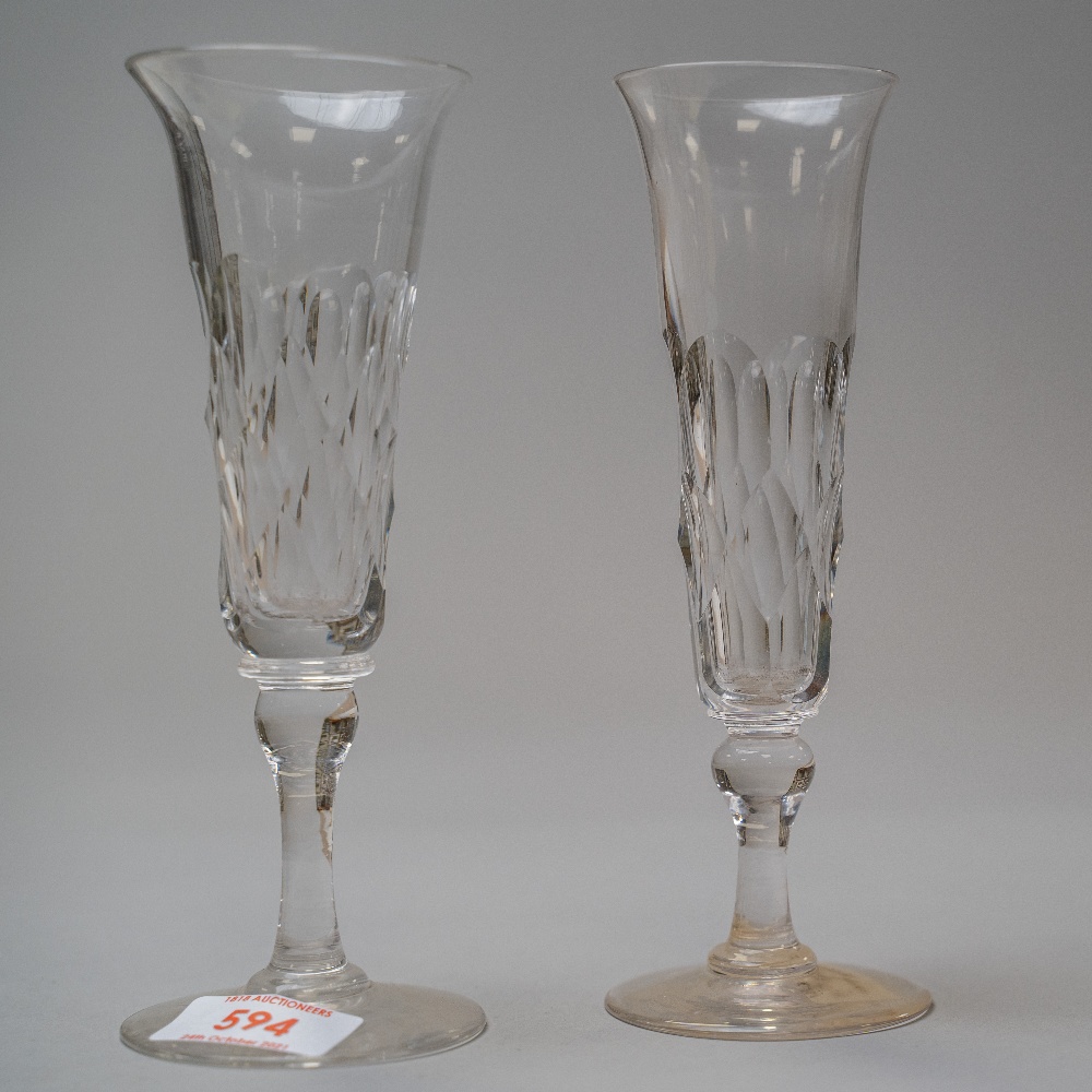 A pair of Victorian champagne flutes having a baluster stem on pain foot with cut body decoration