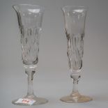 A pair of Victorian champagne flutes having a baluster stem on pain foot with cut body decoration