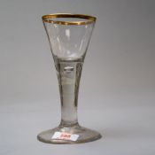 A Victorian wine glass on domed foot having solid stem with air bubble and gilt rim edge with an M