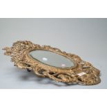 A Victorian hall way mirror of oval form with an elaborately cast iron frame with peacock and cherub