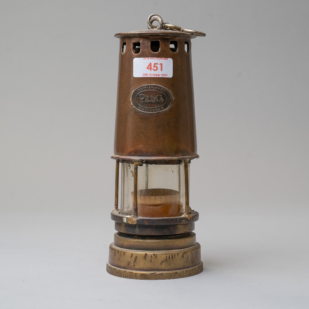 An antique coal miners or similar safety lamp having a copper and brass casing bearing name badge