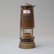 An antique coal miners or similar safety lamp having a copper and brass casing bearing name badge