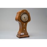 An Edwardian Swiss made tulip or almost balloon shaped oak mantel clock having satinwood and similar