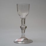 A mid 18th century wine glass with folded foot a central knop stem on plain bowl