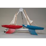 Two vintage wooden sailing yachts, one red and the other blue 'Star yacht, guaranteed to sail,