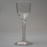 A mid 18th century wine glass with multiform opaque twist stem under a plain bowl