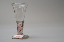 A small wine glass having red and white twist.