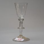 An early 18th century wine glass with folded foot and flat knop hollow stem tear with basal knop