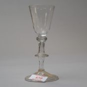 An early 18th century wine glass with folded foot and flat knop hollow stem tear with basal knop