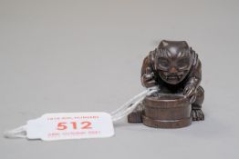 A traditional Japanese Netsuke or Netsky of a Demon or Oni carved in an exotic hardwood and