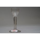 A wine glass having plain stem with a tear on a folded foot with fluted and etched decoration to