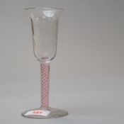 A wine glass having a multi air twist stem opaque with red twist on plain foot and bowl