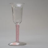 A wine glass having a multi air twist stem opaque with red twist on plain foot and bowl