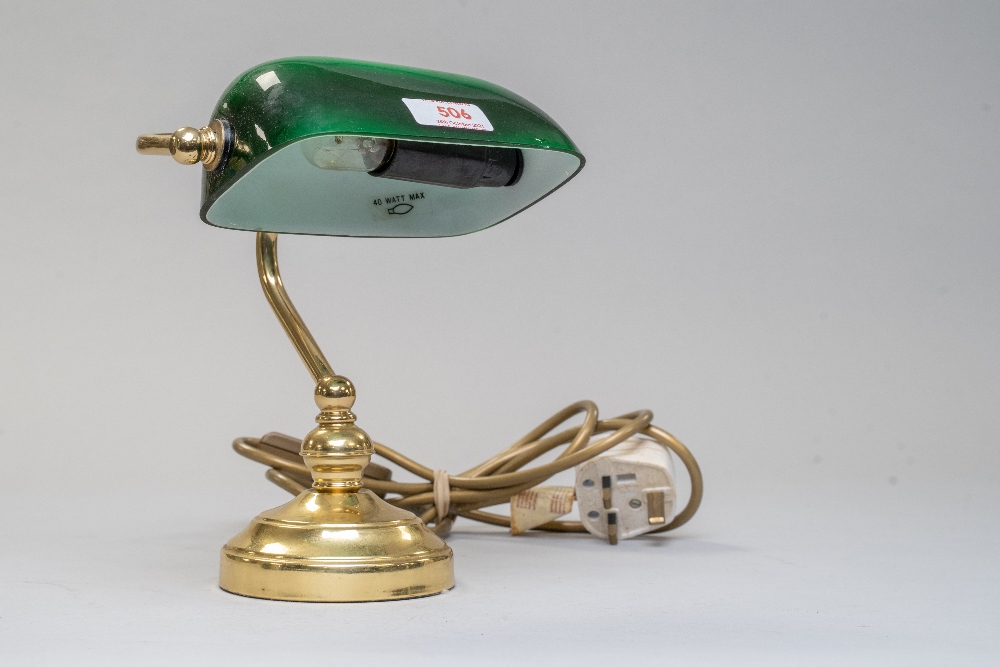 A small bankers style desk top lamp having brass base and bottle green shade.