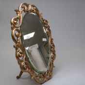 A vintage free standing mirror having bevelled glass and scrolled gilt edging, around 51cm in