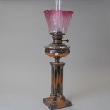 A fine Victorian oil burning lamp having four Corinthian columns supporting copper well with