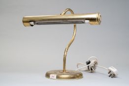 A large brass bankers style desk lamp.