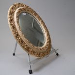 A circular carved wood framed mirror with bevel edged glass and gilt and gesso detailing 45cm