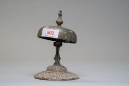 An early 20th century desk top bell having sprung loaded external hammer with swirled motif design