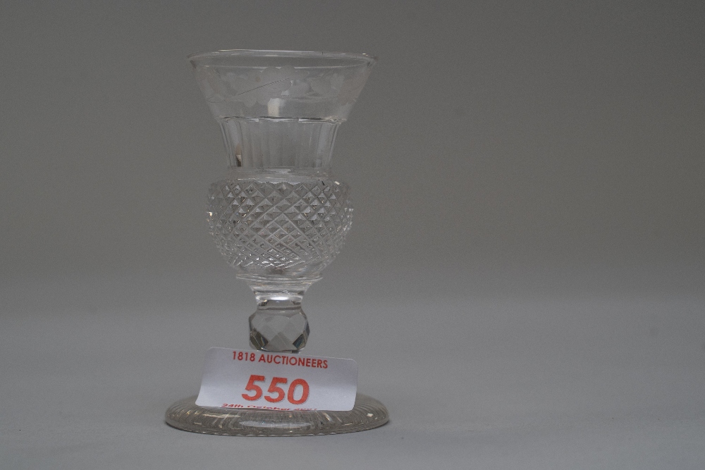 A small wine glass having thistle shaped bowl with decoration.