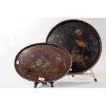 A late 19th/early 20th century round black lacquered tray having painted bird and flower design