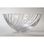 A modernist style clear cut crystal glass fruit bowl having a wave form expanding cut to one side