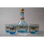 A Murano decanter and glass set in blue having rich gilt detailing of city or harbour town scene,