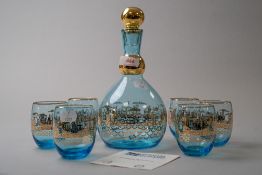 A Murano decanter and glass set in blue having rich gilt detailing of city or harbour town scene,