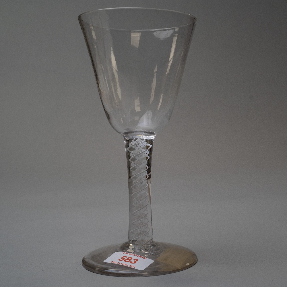 A mid 18th century wine glass with opaque twist spiral stem on plain foot