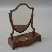 An Edwardian mahogany toilet mirror having shield mirror on shaped three drawer base, with satinwood