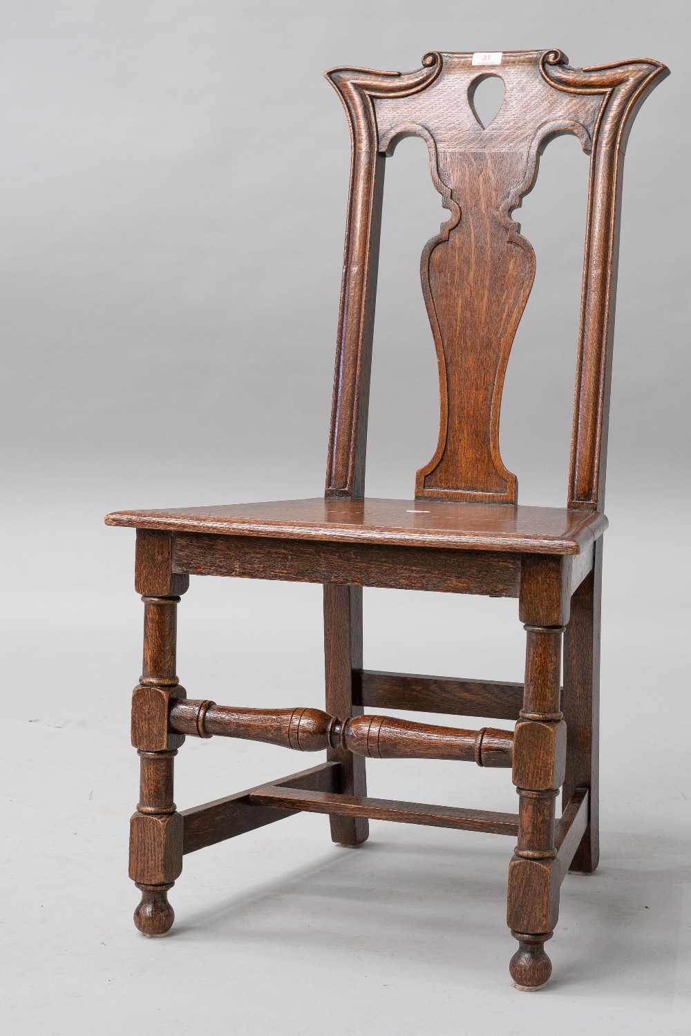 A 19th Century oak hall chair having flared shoulder and teardrop vase back solid seat and turned