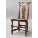 A 19th Century oak hall chair having flared shoulder and teardrop vase back solid seat and turned