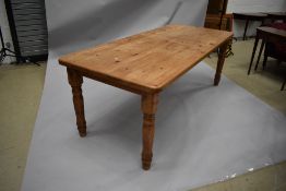 A large natural pine kitchen/dining/banquetting table having turned legs, usually wear and tear