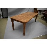 A large natural pine kitchen/dining/banquetting table having turned legs, usually wear and tear