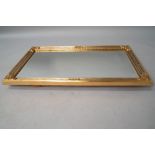 A modern reproduction gilt frame wall mirror in the classical style with foliate embellishments, and