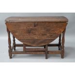 A period oak gateleg table having drawers to each end, on turned legs. Splitting to top and a few