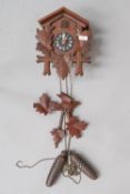 A traditional cuckoo clock, with acorn weights and foliage and bird detail, labelled made in