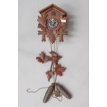 A traditional cuckoo clock, with acorn weights and foliage and bird detail, labelled made in