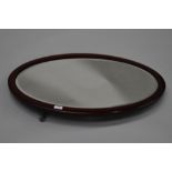 An early 20th Century mahogany framed oval wall mirror, hung in portrait orientation, approx 75 x