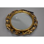 A traditional gilt frame wall mirror having oval centre surmounted with foliate scroll work, overall