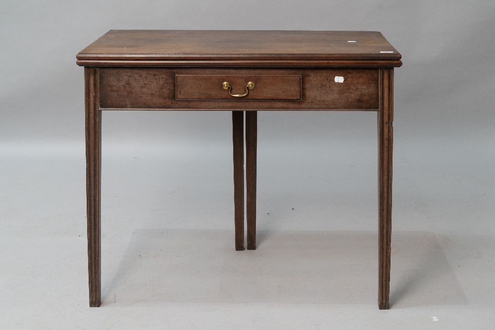 An early 19th Century mahogany fold over tea table having frieze drawer , and fluted legs, closed