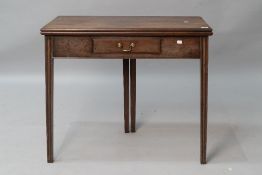 An early 19th Century mahogany fold over tea table having frieze drawer , and fluted legs, closed