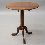 A 19th Century oak pedestal table having circular top on turned column and triple splay legs,