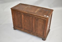 An early 20th Century oak and ply bedding box, of typical three panel design, on bun feet, width