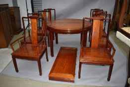 An Oriental hardwood extending dining table and set of eight (six plus two) similar dining chairs,