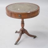 A reproduction Regency style mahogany occasional table of drum form with inset skiver leather top,