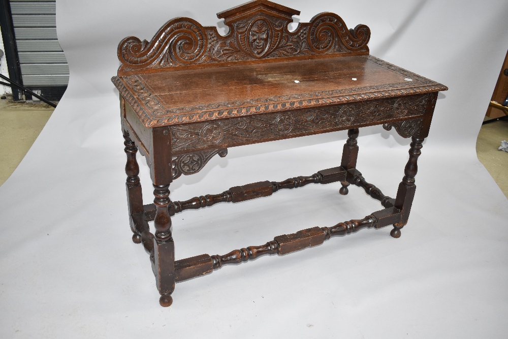 A period oak carved dresser with mythical figure head to the ledge back, lozenge carvung to