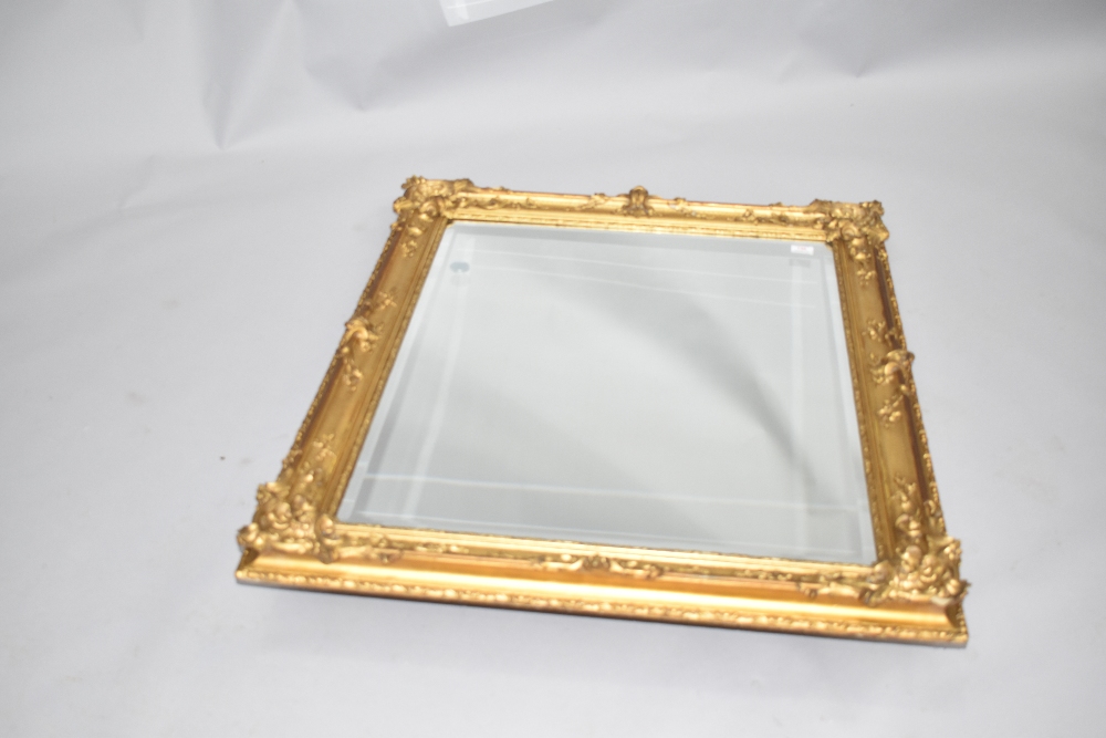 A traditional gilt frame wall mirror of foliate design , currently hung in portait orientation,