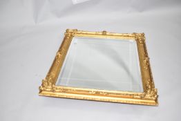 A traditional gilt frame wall mirror of foliate design , currently hung in portait orientation,