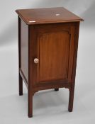 An Edwardian mahogany pot cupboard having open slat back , panelled door, later handle and square